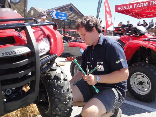 Michael Lilley fits a wheel to an ATV during a Practical Day Challenge.